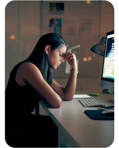 Burnout stressed professional - sitting in front of computer late at night, eyes closed symbolizing stress Burnout stressed professional - sitting in front of computer late at night, eyes closed symbolizing stress