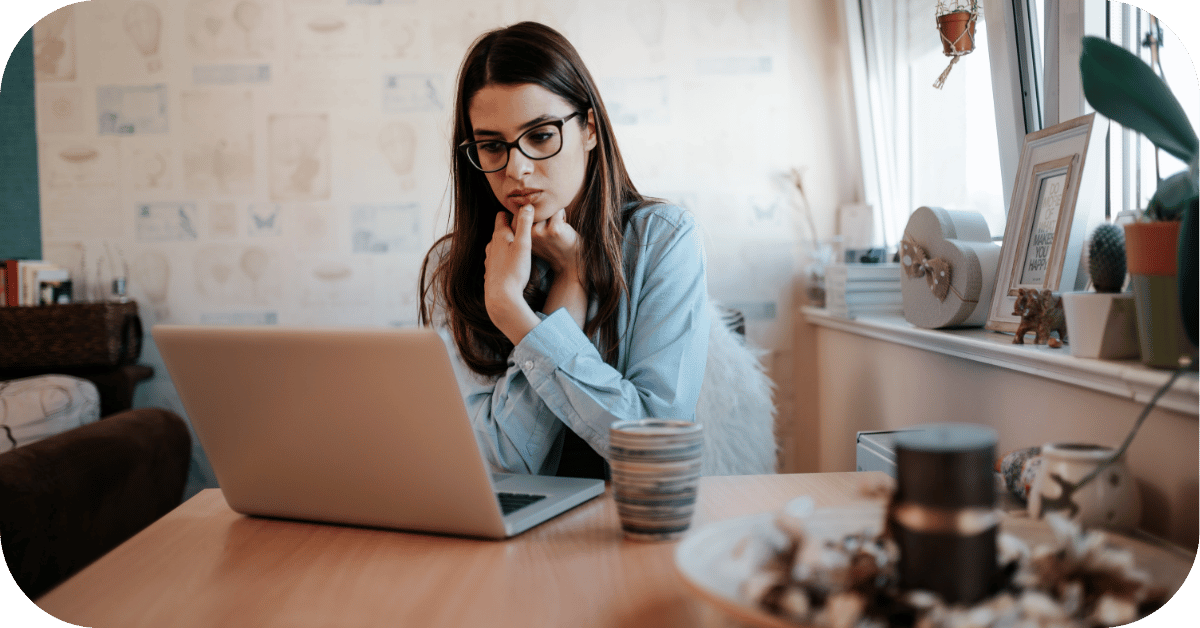 Woman at a laptop staring blankly, feeling the strain of work stress